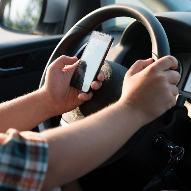 Young man texting while driving