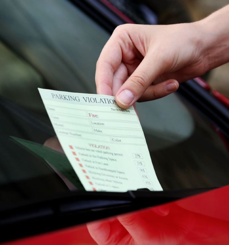 Driver removing traffic ticket from car